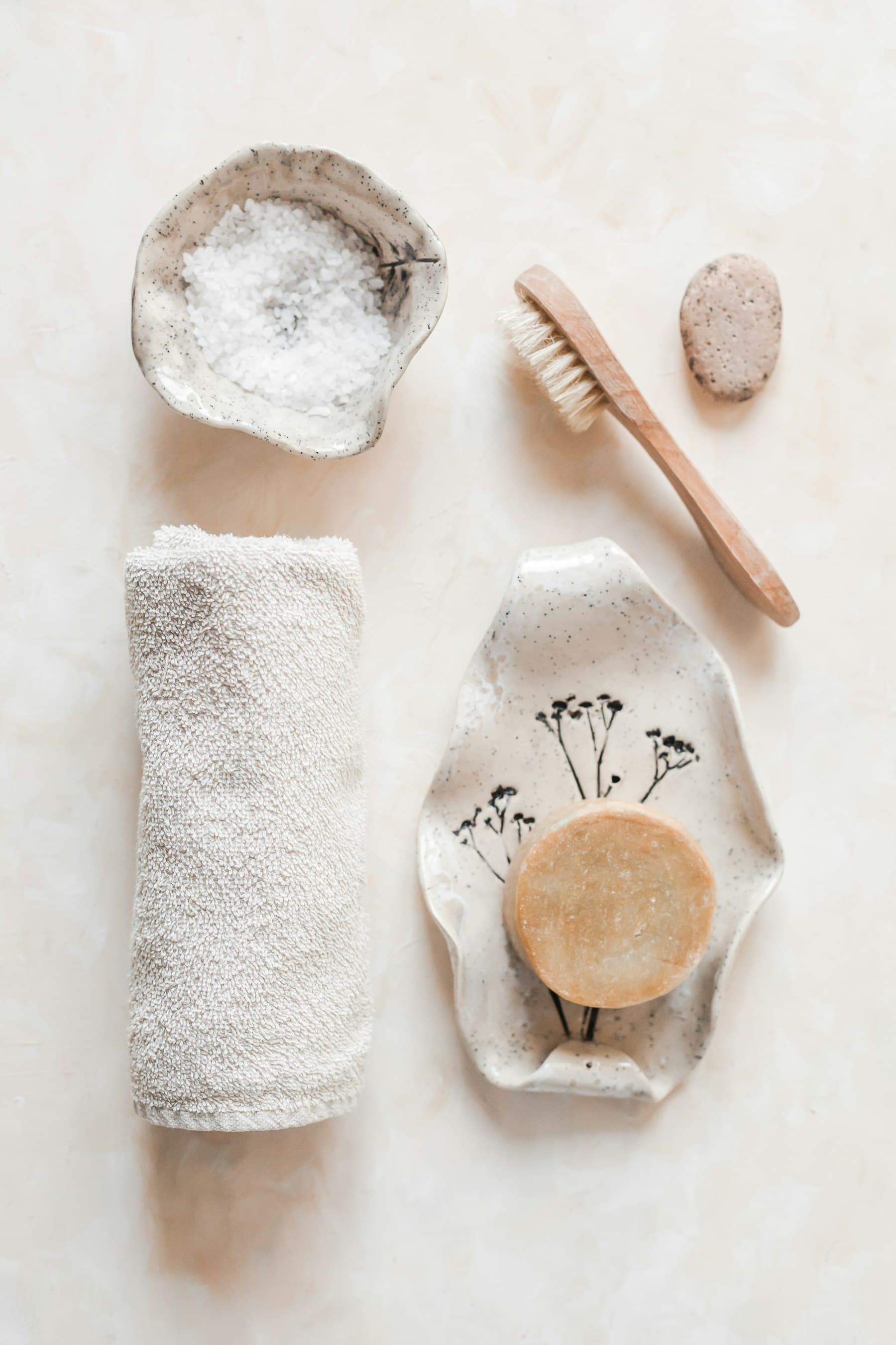 A quiet still life - a rolled linen towel, sea salt in a ceramic bowl, natural soap